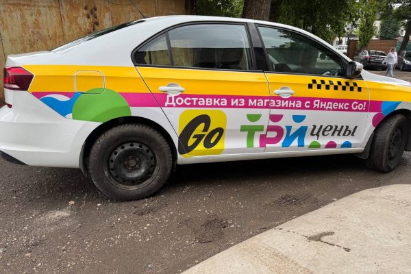 Реклама на белом автомобиле Яндекс GO
